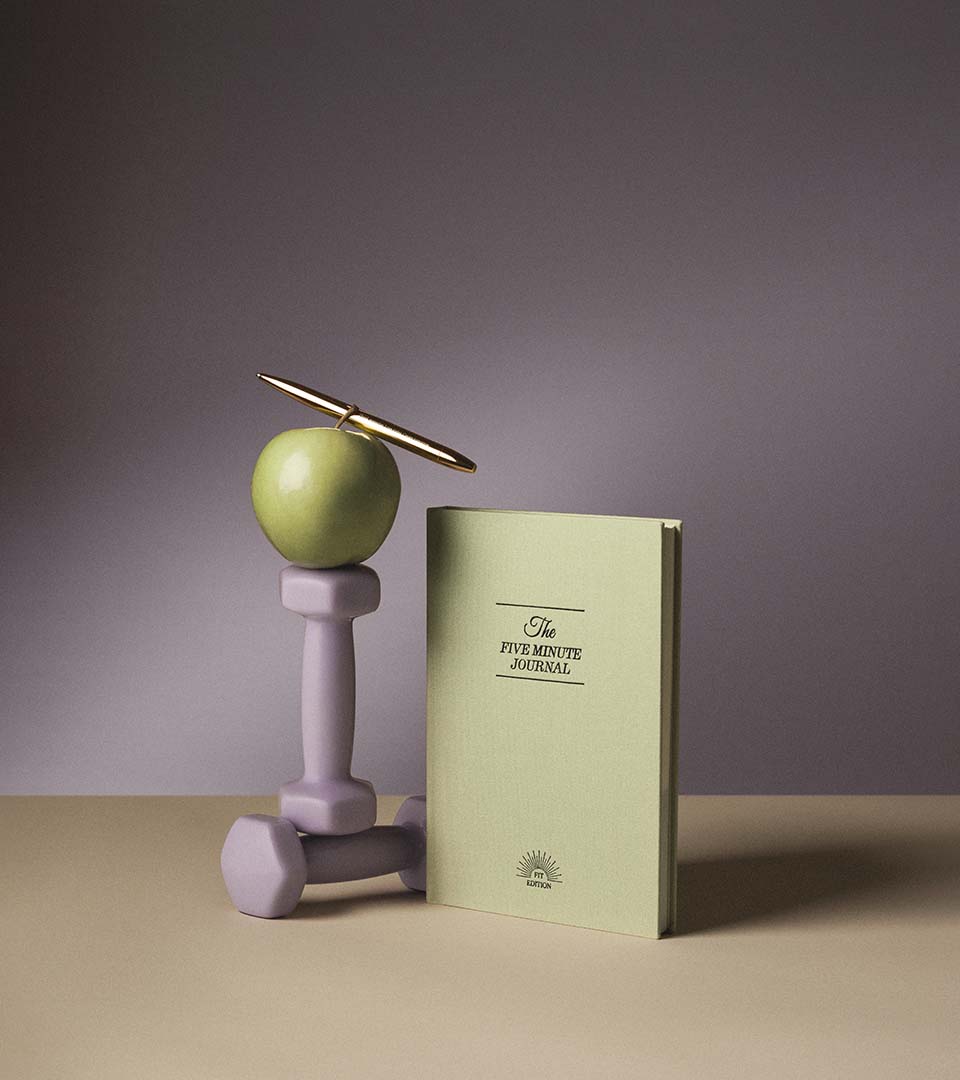 Two hands holding beige hardcover journals titled "The 5 Minute Journal" and "The 5 Minute Life Journal" against a black background with a yellow circle noting "3+ Million Sold".